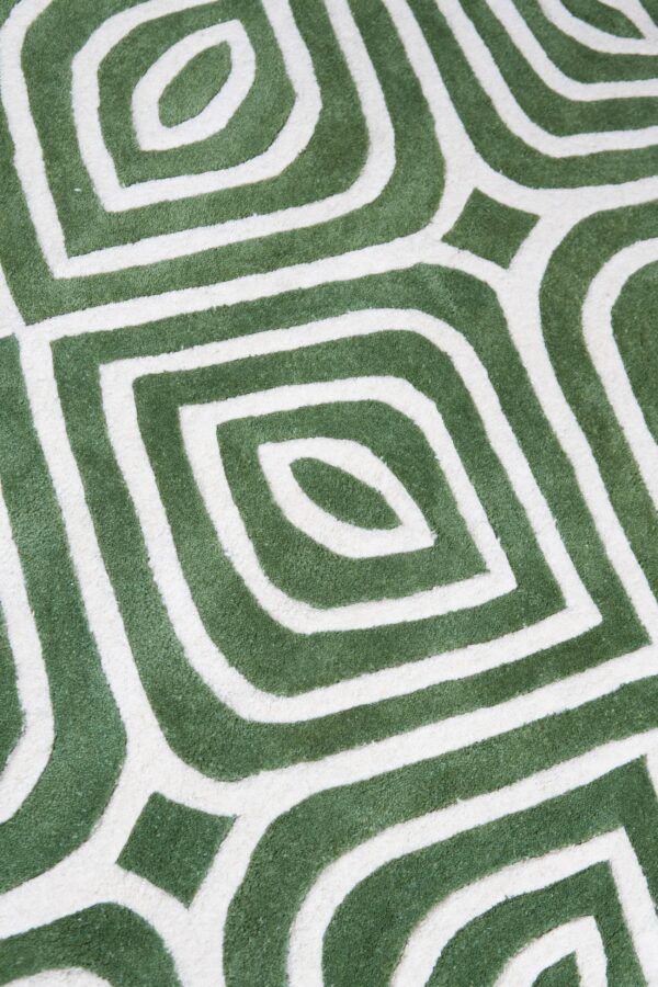 Geometric rug detail in deep green and cream featuring interlocking, concentric, rounded diamond shapes.