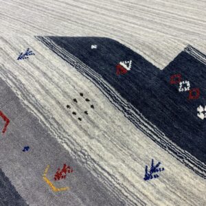 Textured rug with wide diagonal stripes in heathered gray and navy blue featuring small multicolored patterns.