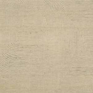 Cream rug featuring a carved geometric pattern of dark gray concentric lines forming angled and rounded shapes.