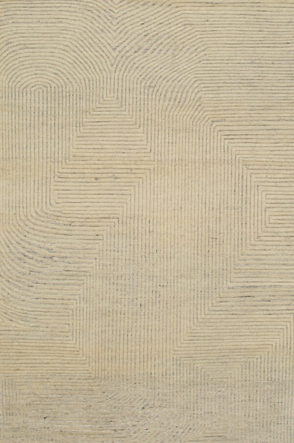 Cream rug featuring a carved geometric pattern of dark gray concentric lines forming angled and rounded shapes.