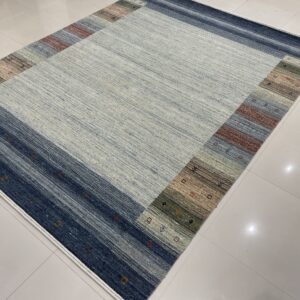 Low-pile striated rug featuring a light gray field and a multicolored geometric border on shiny white tile.