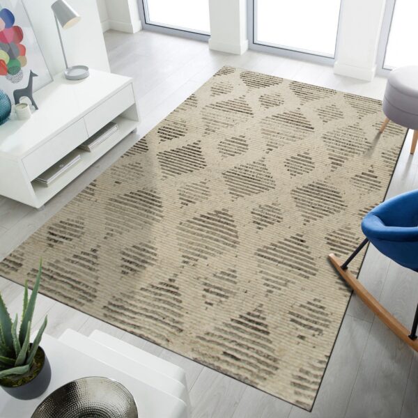 A large beige rug featuring dark gray striped diamond patterns rests on light wood flooring.