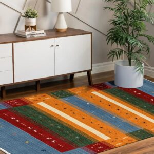 Multicolored striped rug rests on wood flooring below a mid-century modern white console cabinet.