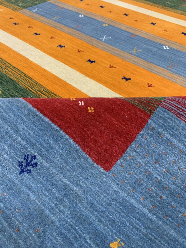 Multicolored striped rug featuring orange, blue, red, and green panels with scattered small geometric motifs.