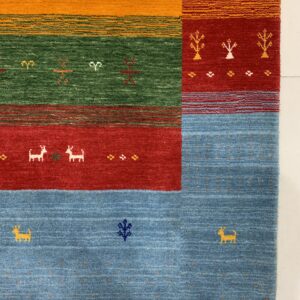 Bright blue, red, green, and orange rug blocks decorated with stylized animal and abstract figures.