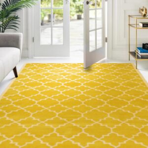 Yellow and white geometric rug anchors a bright room with white walls and open patio doors.
