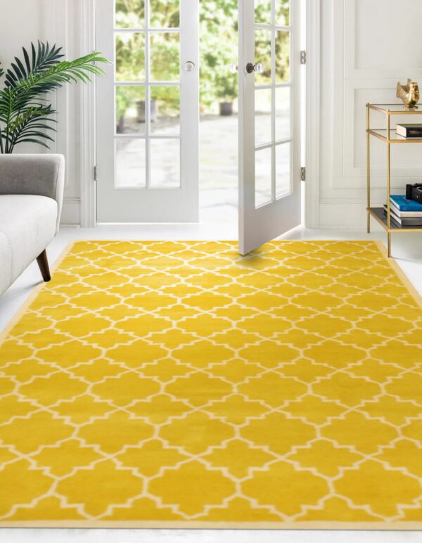 Yellow and white geometric rug anchors a bright room with white walls and open patio doors.