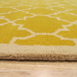 A plush yellow and cream rug with a geometric pattern rests on light wood flooring.