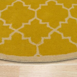 Round yellow cut-pile rug with a cream quatrefoil pattern and border rests on light plank flooring.
