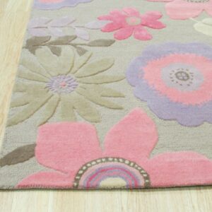 Dimensional rug with large pink, purple, and beige flowers shown against light wood plank flooring.