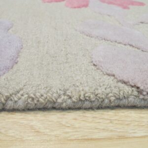 Close-up of a thick, textured rug edge in beige, lavender, and pink over light wood flooring.