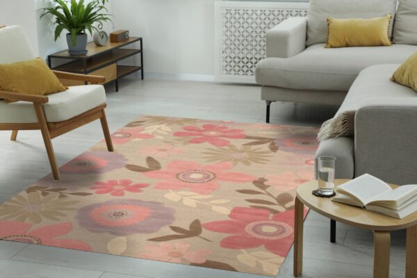 Tan floral area rug with large pink and mauve designs defines a modern living room space.