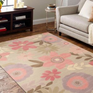 A beige rug featuring large pink, lavender, and brown floral patterns rests on wood flooring beside a gray armchair.
