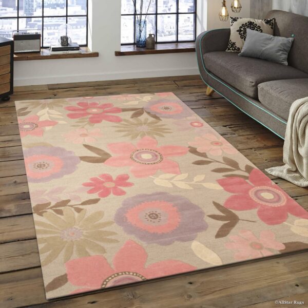 Beige rug with pink and lavender large floral patterns anchors a modern living room with distressed wood floors.