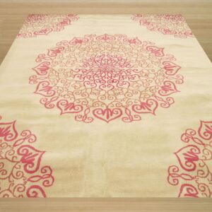 Large pink swirling medallion and corner patterns decorate a cream rug over light plank flooring.