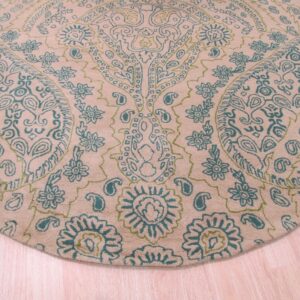 Round rug with high pile texture featuring teal and lime green floral paisley designs on a light tan background.
