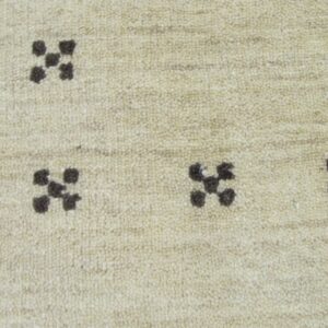 A close-up view of a textured cream rug with scattered dark brown geometric cross motifs.