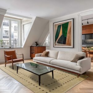 Beige rug with dark scattered geometric patterns lies beneath a textured sofa on herringbone wood floor.