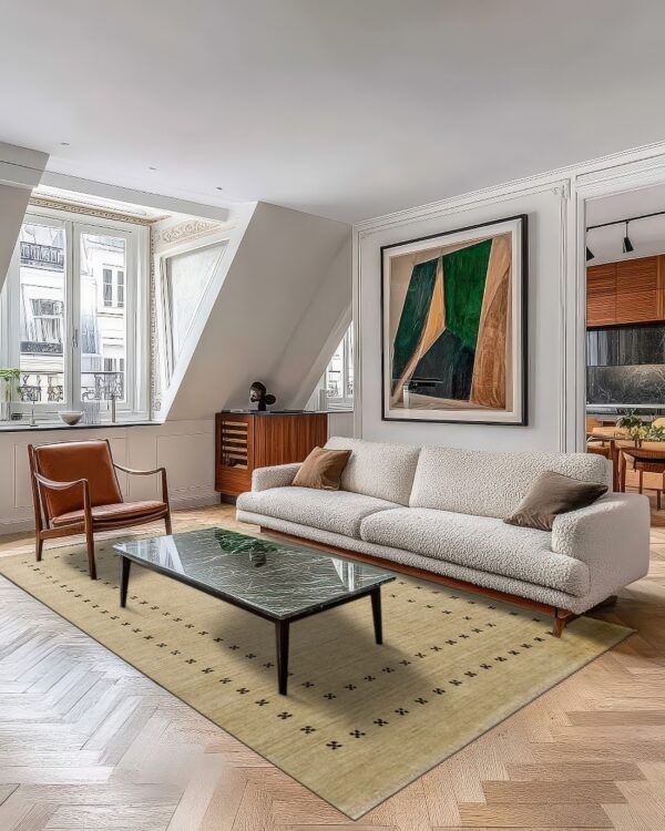 Beige rug with dark scattered geometric patterns lies beneath a textured sofa on herringbone wood floor.