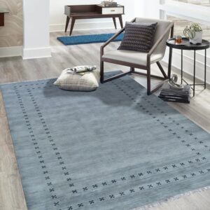 Light blue area rug featuring a repeating dark geometric border anchors a modern seating area.