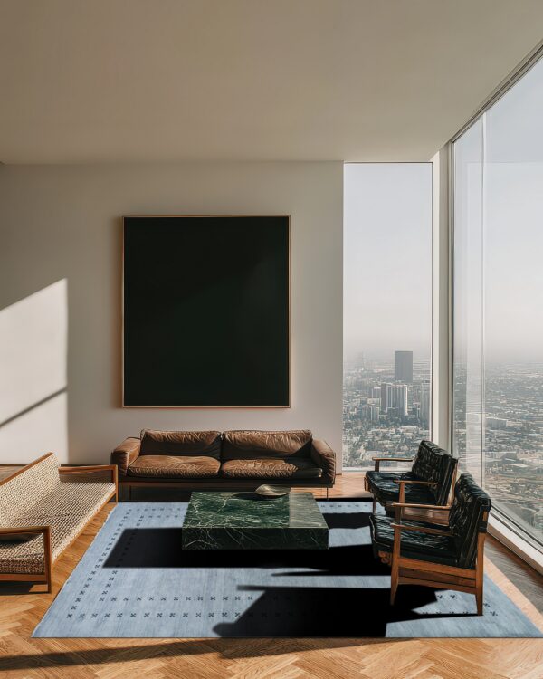 A blue patterned rug sits on wood floors in a high-rise room with leather furniture and a green marble table.