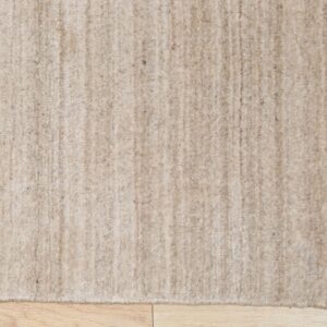 Beige high-pile rug featuring slight vertical striping rests on light wood plank flooring.