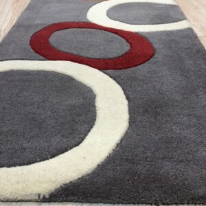 A gray high-pile runner featuring large carved rings in white, red, and orange over light wood.