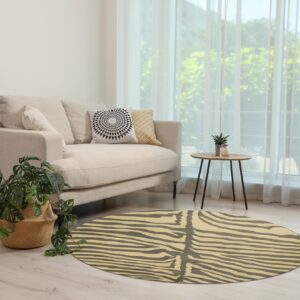 A round rug with a cream and dark gray striped animal print pattern is on light wood flooring.
