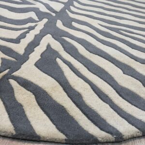 Close view of a plush gray and cream zebra pattern rug on light brown wood flooring.