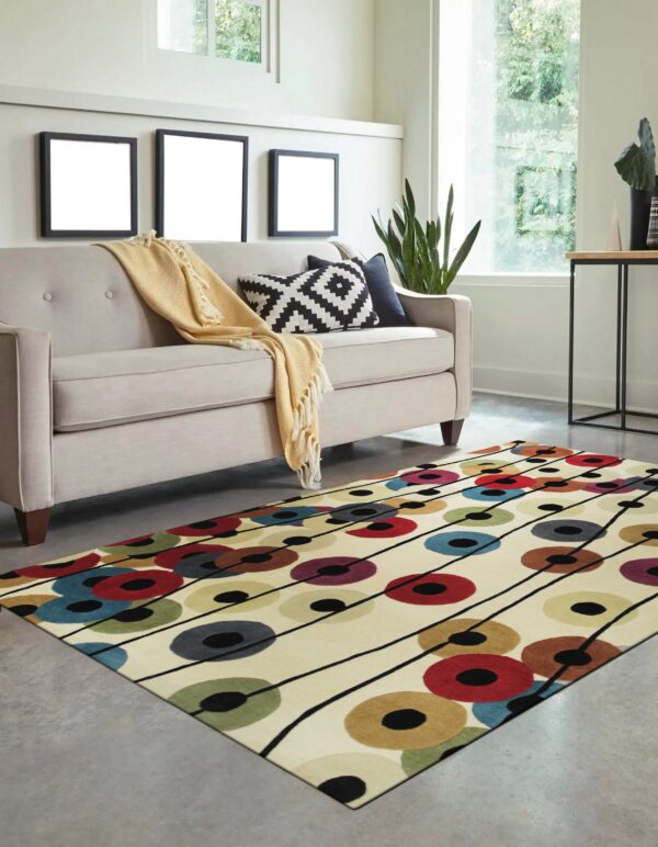 Cream rug with abstract multicolored circles and black connecting lines anchors a modern beige sofa.