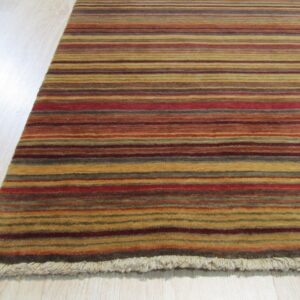Close-up of a medium-pile rug featuring horizontal stripes in red, gold, brown, and green on light wood flooring.