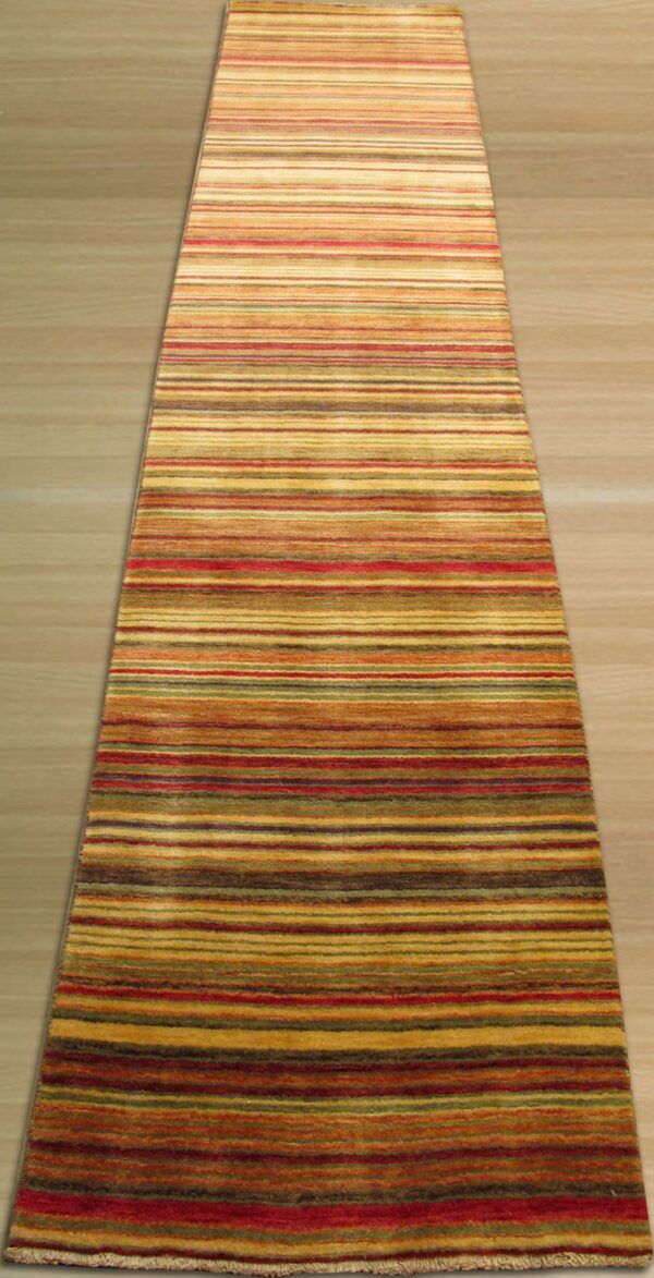 A striped runner rug with red, yellow, brown, and green earth tones lies on light wood flooring.
