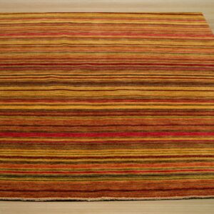 Striped area rug in warm tones of gold, red, and brown rests on light wood flooring.