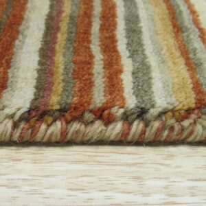 High-pile striped rug in rust, cream, and olive rests on light wood, showing the thick serged edge.