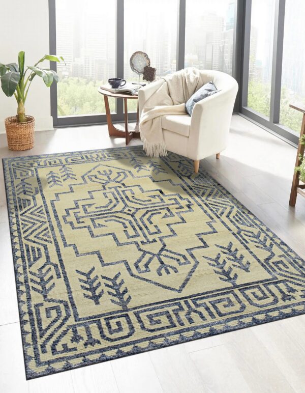 Cream and blue geometric rug under a white armchair in a bright room with large windows.