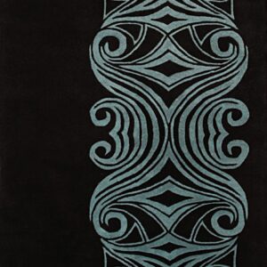 Close-up of a black rug showing a vertical teal border with deeply carved symmetrical scrollwork designs.