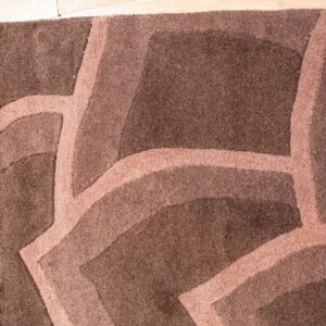 Textured dark brown rug with a lighter brown abstract curved pattern on light wood flooring.