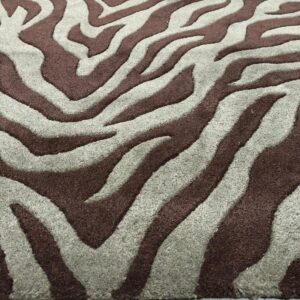 Close-up of a high-pile rug featuring dark brown and grayish-taupe stripes in a zebra pattern on light wood flooring.