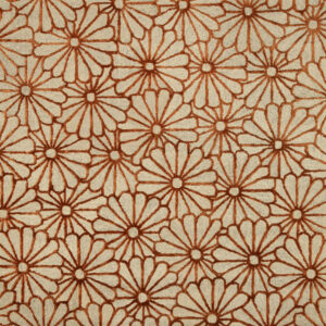 Close-up of a high-low pile rug with a repeating rust floral pattern on a beige background.