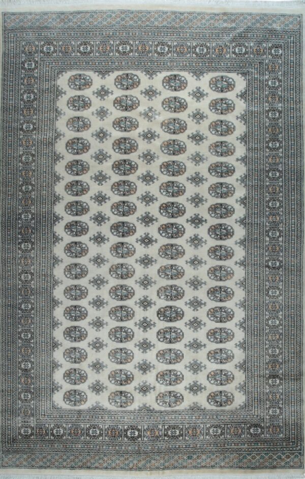Cream area rug with repeating blue, grey, and peach geometric medallions and intricate, multi-layered borders.