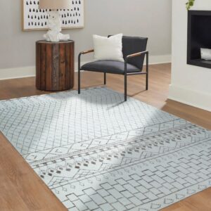 Light blue geometric rug with brown tribal patterns grounds a modern chair on wood flooring.