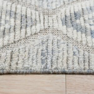 Cream and gray geometric high-low pile rug texture detail resting on light wood flooring.