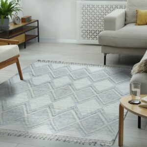 Textured flatweave rug featuring blue, tan, and white stacked diamond patterns in a bright living room setting.