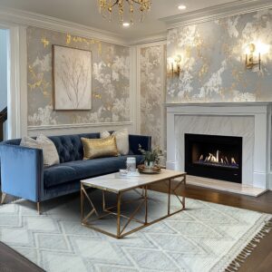 Cream rug with gray diamond patterning is placed on dark wood floors in front of a blue couch.