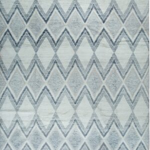 Off-white textured rug features large interlocking diamond patterns in various shades of gray and blue with short tassels.