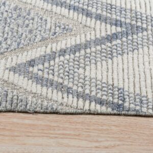 Chunky ribbed rug in blue and cream colors displaying a geometric pattern on light wood flooring.