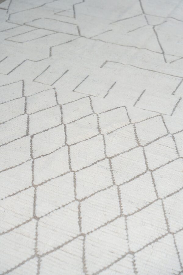 Textured cream rug with gray geometric diamond and abstract linear patterns.