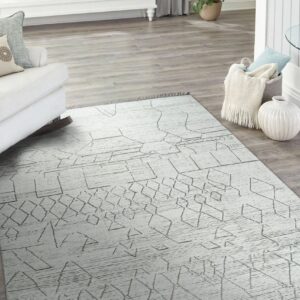 Abstract geometric lines in taupe cover a textured off-white rug on light gray wood planks.