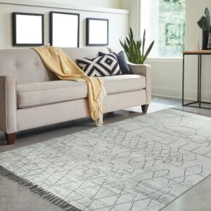 Low pile white rug featuring textured abstract gray diamond patterns under a modern light beige couch.