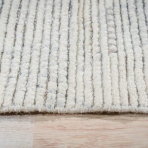 High-pile cream rug with raised vertical ribs and gray flecks sits on light wood planks.